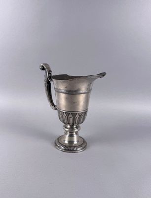an antique silver cup with a handle on a white background