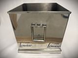 a silver metal container with a handle on a table
