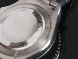 a close up of a watch on a black surface