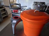 un grand seau orange posé par terre dans une cuisine