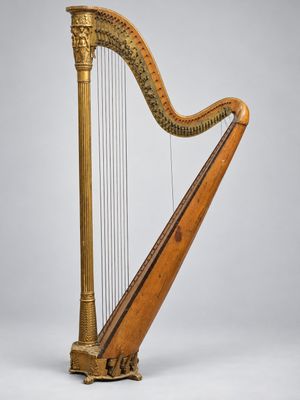 une grande harpe en bois posée sur une surface blanche