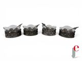 four pieces of silverware with spoons and spoon rest on a white surface