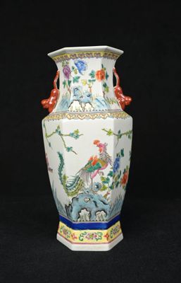 a vase with a bird on it on a black background