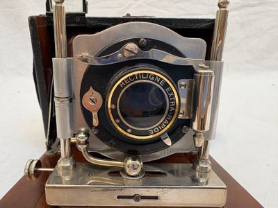 un appareil photo à l'ancienne posé sur un trépied en bois