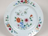 une assiette blanche décorée de fleurs et de feuilles colorées