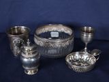 trois tasses en argent et un bol posés sur une table