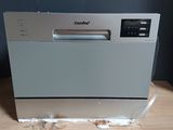 an image of a dishwasher sitting on top of a wooden table