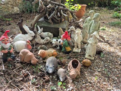 a lot of garden gnomes that are sitting in the dirt