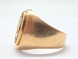 a gold signet ring with a diamond in the center