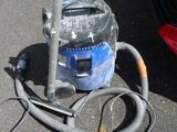 a vacuum and a hose on the ground next to a car