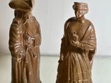 two figurines that are sitting on a glass table