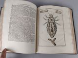 someone is holding an open book with a drawing of a bug on it