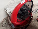 un ventilateur rouge posé sur une table, à côté d'une chaise rouge