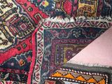 a close up of a rug with a pink cushion on it