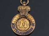a close up of a gold medal with a crown on it