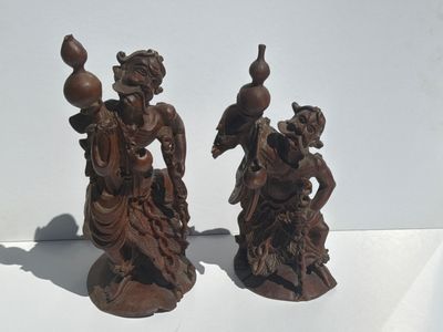 two figurines that are sitting on a white surface