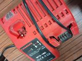 a close up of a red corded drill on a wooden table