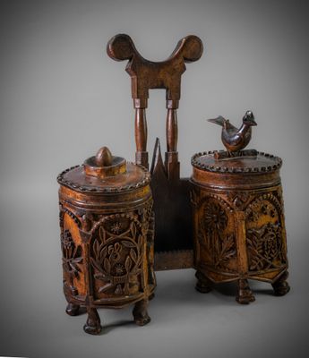 two wooden boxes with carvings on them and a bird sitting on top of them
