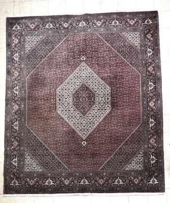 an oriental rug with a diamond design on a white tile floor