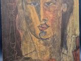 une peinture représentant le visage d'une femme sur un morceau de bois