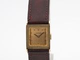 une photo d'une montre-bracelet plaquée or avec un bracelet en cuir marron