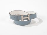 une ceinture bleue et blanche avec une boucle argentée sur fond blanc