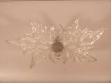 a glass candle holder that has a leaf design on it