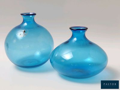 deux vases bleus posés l'un à côté de l'autre sur une table