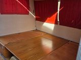 a bed in the back of a camper with red curtains