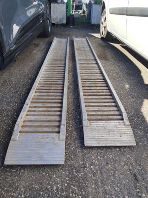 two wooden ramps on the ground next to a car