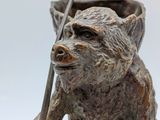 a statue of a bear with a stick in his hand