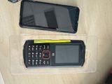 two cell phones sitting on a table next to each other