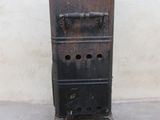 an old metal stove sitting on top of a cement floor