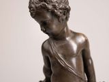 an image of a statue of a boy with a bow on his shoulder