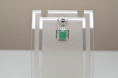 un petit pendentif de forme carrée orné d'une pierre verte
