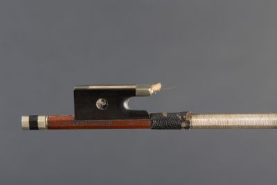 a close up of a violin bow with a piece of wood sticking out of it