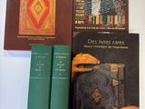 trois livres posés sur une table, les uns à côté des autres, sur une surface blanche
