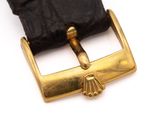 a black leather strap with a gold buckle on it