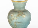a blue vase with gold decoration on it on a white surface