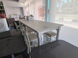 une table et des chaises dans une pièce avec une grande fenêtre