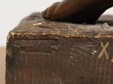 a bronze statue of a hand on a wooden block