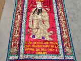 une image représentant un tissu rouge sur lequel figure le portrait d'un homme
