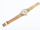 an image of a gold watch with a white face on a white surface