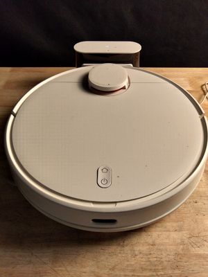 a white robot sitting on top of a wooden table