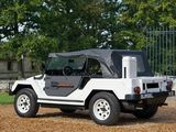 a white jeep parked in front of a gate