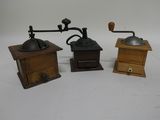 three different types of coffee grinders sitting on a white surface