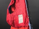 a red jacket on a mannequin stand against a black background