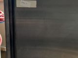 a stainless steel refrigerator in a room with a window