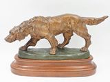 statue en bronze d'un chien sur un socle en bois sur fond blanc