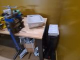 a small workbench in the corner of a room with a lot of clutter on it